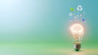 Glowing light bulb with green energy icons including solar panels, wind turbines and recycling symbols on gradient background for sustainability concepts.