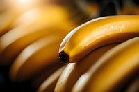 Fresh ripe yellow bananas in macro close-up view showing natural texture and curves against dark background, selective focus creates artistic food photography.