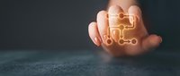 Hand holding glowing digital network connection icon with circuit board pattern on dark background for technology and connectivity concepts.