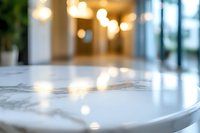 Luxurious white marble table surface with soft bokeh lights in background creating elegant atmosphere in modern interior space. Perfect for luxury design projects.
