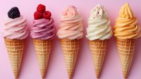 Colorful soft serve ice cream cones in row showing different flavors topped with berries and sprinkles on pink background, sweet frozen dessert variety.