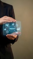 Businesswoman holding transparent tablet displaying productivity icons, charts, and workflow symbols. Digital business concept for efficiency and performance management.