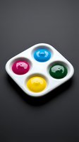 Four colorful glossy spheres in white palette with blue, magenta, yellow, and green bubbles. Isolated on dark background for design, web, and creative projects.