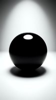 Black sphere with dramatic lighting and shadow on white surface creating minimalist artistic composition for modern design projects.