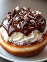 Decadent chocolate cream donut topped with whipped cream, dark chocolate ganache drizzle and chocolate shavings on white plate, macro food photography.