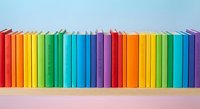 Colorful rainbow books arranged in row on shelf against blue background for education, library, reading and learning concepts.