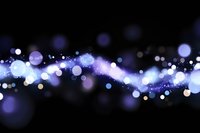Abstract purple and blue bokeh lights flowing across dark background creating magical glowing effect for digital design and creative projects.