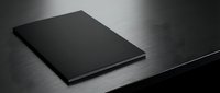 Sleek black notebook with minimalist cover design placed on brushed metal surface for professional business and office applications.