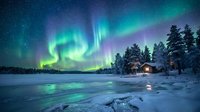 Spectacular northern lights aurora borealis dancing over snow-covered winter landscape with cozy cabin and evergreen trees under starry night sky.