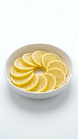 Fresh lemon slices arranged in white ceramic bowl on clean background for culinary and healthy lifestyle content.