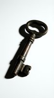 Antique iron skeleton key with ornate oval bow and textured shaft isolated on white background, casting shadow. Suitable for vintage design, historical concepts, security themes, and decorative projects.