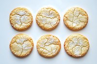 Six golden crinkle cookies with powdered sugar dusting arranged in rows on white background, homemade baked goods for dessert recipes and food blogs.