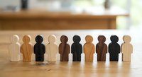 Diverse wooden human figures in row representing teamwork, inclusion and unity concepts for business presentations and diversity training materials.