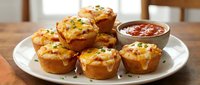 Savory egg muffins with cheese and herbs served on white plate with tomato sauce, perfect for breakfast, brunch or meal prep recipes.