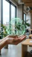 Hand holding glowing green recycling symbol in modern office with plants and windows, representing sustainability, environmental responsibility, and eco-friendly business practices.