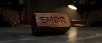Wooden block with EMDR letters carved into surface, representing eye movement desensitization and reprocessing therapy concept for mental health treatment.