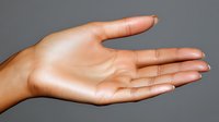 Female hand with open palm showing empty gesture against gray background, clean manicure and natural skin tone, suitable for business and communication concepts.