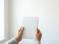 Mature adult hands holding blank white canvas against neutral wall background, suitable for mockup, branding, and advertising campaigns.