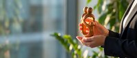 Businessman hands holding glowing light bulb in modern office environment symbolizing innovation creativity and bright ideas for business solutions.
