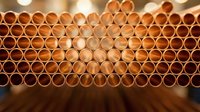 Copper pipes arranged in geometric honeycomb pattern with warm lighting creating industrial construction plumbing background for modern design projects.