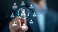 Business professional in suit selecting glowing user icon from digital network interface, demonstrating HR management and team leadership concept.
