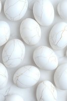 White eggs with golden kintsugi-style cracks arranged on light background, creating minimalist artistic pattern for luxury design and packaging concepts.