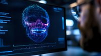 Digital holographic skull visualization on computer monitor with glowing blue wireframe structure and anatomical details in dark medical office setting.