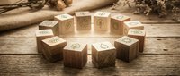 Wooden blocks with eco-friendly icons arranged in circle on rustic table with natural rope and dried plants for sustainable business concepts.