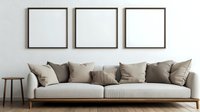 Modern living room interior with light gray sofa, beige cushions and three empty square frames on white wall. Wooden side table adds minimalist accent.