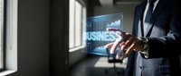 Professional businessman in dark suit interacting with holographic business analytics display showing growth charts and data visualization in modern office.
