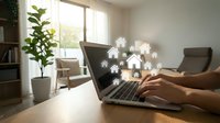 Person using laptop with glowing house icons for real estate property search and home buying online platform in modern living room interior.