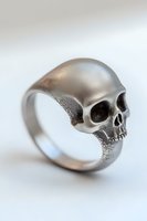 Silver skull ring with detailed anatomical features on light background, showcasing intricate metalwork and gothic jewelry design for alternative fashion accessories.