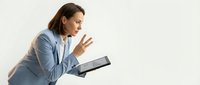 Professional businesswoman in light blue blazer gesturing while holding tablet during presentation or meeting on white background.
