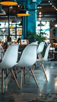 Modern cafe interior with white chairs and industrial pendant lamps in turquoise ambiance. Stylish restaurant setting with bokeh lights and minimalist furniture.