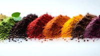 Vibrant natural food coloring powders arranged in rainbow spectrum on white background, organic spices and superfood supplements for healthy cooking and baking.