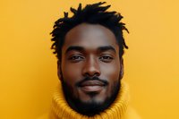 Young African American man with dreadlocks wearing yellow turtleneck sweater against bright yellow background for lifestyle and fashion content.