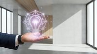 Businessman hand presenting glowing lightbulb with geometric network connections in modern office space representing innovation and creative solutions.