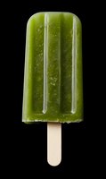 Green frozen popsicle ice cream on wooden stick isolated on black background for summer refreshment and dessert advertising campaigns.