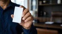 Man in dark blue shirt holding blank white card for business branding, corporate identity, and professional marketing presentations.
