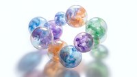 Colorful transparent glass marbles with swirled patterns in blue, purple, orange and green hues scattered on white surface creating rainbow reflections.