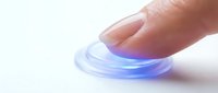 Finger touching transparent blue glowing disc on white surface, representing technology, innovation, and futuristic interaction for digital design projects.