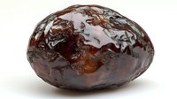 Ripe dark date fruit macro shot showing wrinkled glossy skin texture and natural amber highlights on white background, isolated for food photography and packaging.