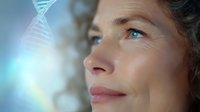 Mature Caucasian woman with blue eyes looking up thoughtfully at glowing DNA strand against blurred background, representing genetic testing and medical innovation.