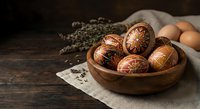 Traditional decorated Easter eggs in wooden bowl with natural patterns on rustic table setting for spring holiday celebration and cultural traditions.