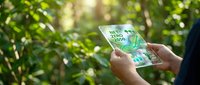Businessman using smartphone with ESG environmental social governance concept in green forest for sustainable business and corporate responsibility.