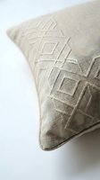 Beige linen throw pillow with tonal geometric embroidery, close-up detail on white background, natural texture for home decor.