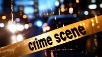 Yellow police crime scene tape barrier against blurred urban night background with bokeh lights and police car emergency lighting.