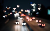 Romantic city night scene with heart-shaped bokeh lights from traffic and street illumination creating dreamy Valentine atmosphere for love concepts.