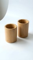 Two natural bamboo cylindrical cups or containers displayed on white background, suitable for eco-friendly product design, sustainable kitchenware, and organic home decor applications.