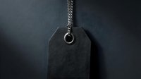 Black blank price tag with metal chain on dark textured background for retail labeling and product pricing applications.